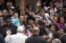 People greet and take pictures of Pope Francis as he visits the Varginha slum in Rio de Janeiro, Brazil, Thursday, July 25, 2013. Francis on Thursday visited one of Rio de Janeiro's shantytowns, or favelas, a place that saw such rough violence in the past that it's known by locals as the Gaza Strip. (AP Photo/Victor R. Caivano)
