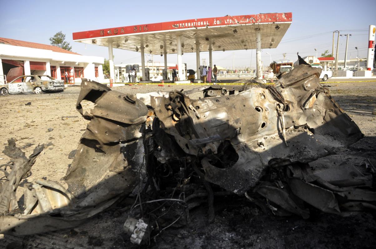 The wreckage of a car is seen at the site of a blast at a petrol station in Kano, Nigeria. Saturday, Nov. 15, 2014. A bomb exploded Friday night in northern Kano city, the second largest population center in Nigeria, killing six people including three police officers, according to the police. (AP Photo/Muhammed Giginyu)
