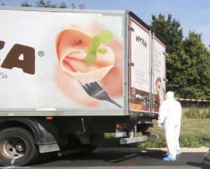 Forensic police officer stands next to a parked truck in which up to 50 migrants were found dead on a motorway near Parndorf