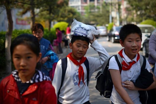 Crianças chinesas saindo de uma escola de Pequim em 3 de maio de 2013