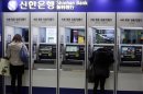 Customers use the automated teller machine at a branch of Shinhan Bank in Seoul, South Korea, Thursday, March 21, 2013. Investigators have traced a coordinated cyberattack that paralyzed tens of thousands of computers at six South Korean banks and media companies to a Chinese Internet Protocol address, authorities in Seoul said Thursday. (AP Photo/Lee Jin-man)