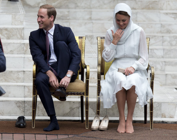 Prince William and his wife Kate, the Duke and Duchess of Cambridge take their shoes off before entering a mosque in Kuala Lumpur, Malaysia, Friday, Sept. 14, 2012. (AP Photo/Mark Baker)