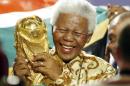 ARCHIVO - En esta foto del 15 de mayo de 2004 el expresidente sudafricano Nelson Mandela levanta el trofeo de la Copa del Mundo en Zurich, Suiza, luego de que el comité ejecutivo de la FIFA anunció que Sudáfrica sería la sede del Mundial de fútbol del 2010. Mandela fue clave para ayudar al país a conseguir albergar el torneo. El expresidente sudafricano falleció el jueves 5 de diciembre de 2013 a los 95 años. (AP Photo/Michael Probst, Archivo)
