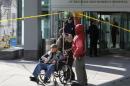 A man in wheelchair is taken away from the building where a shooting occurred at Brigham and Women's hospital in Boston