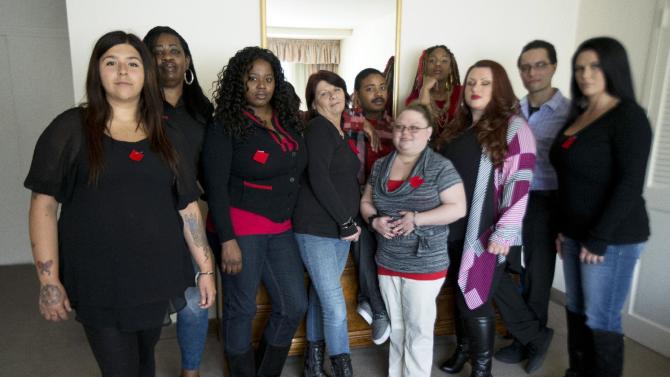 Makenzie Vasquez, from left, Pamala Hunt, Latonya Suggs, Ann Bowers, Nathan Hornes, Ashlee Schmidt, Natasha Hornes, Tasha Courtright, Michael Adorno and  Sarah Dieffenbacher, pose for a picture in Washington, Monday, March 30, 2015. Former and current college students calling themselves the “Corinthian 100” say they are on a debt strike and refuse to pay back their student loans. The name comes from Corinthian Colleges Inc., which operated the for-profit Everest College, Heald College and WyoTech schools before agreeing last summer to sell or close its 100-plus campuses.     (AP Photo/Manuel Balce Ceneta)