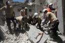 Civil defense members search for survivors under the rubble at a site hit by airstrikes in the rebel-controlled town of Ariha in Idlib province