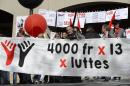 In this picture taken May 1, 2014, demonstrators demand on a banner a monthly salary of at least 4,000 Swiss Francs (US dollar 4,490), in Lausanne, Switzerland. In a nation of mostly haves and have-mores, Swiss voters head to the polls Sunday, May 18, 2014, to decide on a trade union's proposal that would create a new nationwide minimum wage and set it at 22 Swiss francs (US dollar 24.70) an hour _ the world's highest. (AP Photo/Keystone, Laurent Gillieron)