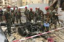 Lebanese military police inspect the remains of a vehicle, at the site of an explosion in Beirut's southern suburbs