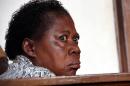 In this photograph taken on Thursday, March 20, 2014, a Ugandan nurse, Rosemary Namubiru, sits in court in the capital Kampala, Uganda. She is accused of injecting a two year old boy Mathew Mushabe with HIV/Aids virus. Goaded by journalists who wanted a clear view of her face, the Ugandan nurse looked dazed and on the verge of tears. The Ugandan press had dubbed her "the killer nurse" after the HIV-infected medical worker was accused of deliberately injecting her blood into a two-year-old patient. (AP Photo)