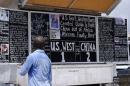 A man reads a board extolling China's contribution to the fight against Ebola, in Monrovia