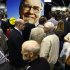 A huge picture of Berkshire Hathaway Chairman Buffett looks over shareholders swarming the exhibit floor where companies owned by Berkshire display and sell their products, in Omaha