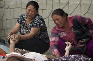 Unidentified relatives mourn near the bodies of those &hellip;
