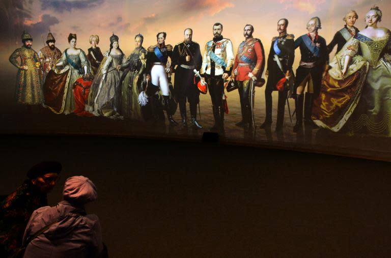 Посетители смотрят на огромные портреты монархов России на выставке "Моя история. Романовы", в Москве Манеж, на 14 ноября 2013