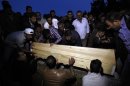 Relatives of Mehmet Tas, a victim of a car bomb attack, lower his coffin into a grave in Reyhanli