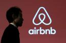 A man walks past a logo of Airbnb after a news conference in Tokyo