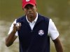 U.S. golfer Woods holds up his ball after sinking a birdie putt to halve the 17th hole during the afternoon four-ball round at the 39th Ryder Cup matches at the Medinah Country Club