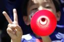 A young Japan soccer supporter plays the vuvuzela before the international friendly soccer match between Japan and Ivory Coast in Sion