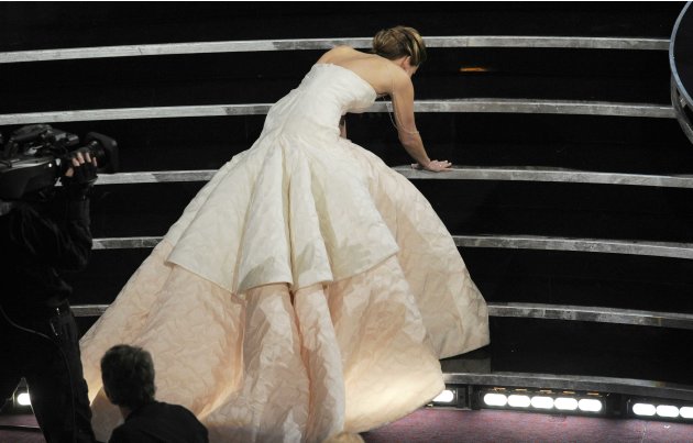 Jennifer Lawrence stumbles as she walks on stage to accept the award for best actress in a leading role for