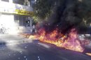 Demonstrators burn tyres to block a road to protest against Syria's President Bashar al-Assad in al-Midan district of Damascus