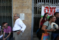 <p>               Protesters gather outside Bank of Greece with the banner reads ''No'' in Athens, Monday, June 30, 2012.  The state-run bank was privatized last week, in a no-cash transfer to the private Piraeus Bank. Bank workers on Monday held a 24-hour strike to protest cuts under Greece austerity program. (AP Photo/Thanassis Stavrakis)