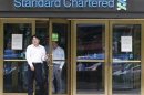 Employees of Standard Chartered leave a branch of the bank in central Seoul