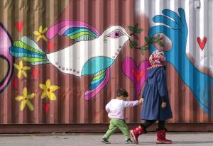 Children walk by a painted container as people wait&nbsp;&hellip;