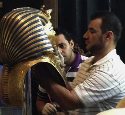 In this Aug. 12, 2014, photo provided by Jacqueline Rodriguez, a man glues the beard part of King Tutankhamun's mask back on at the Egyptian Museum in...
