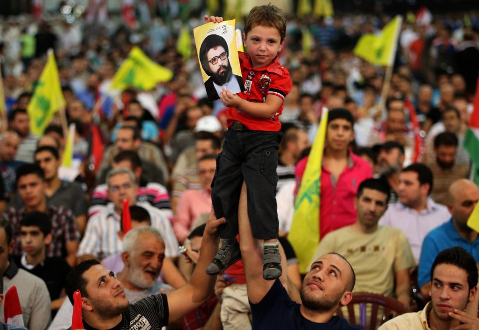 Hezbollah supporters hold up a boy with a portrait of late Hezbollah leader Sheik Abbas al-Moussawi, during a rally to mark Jerusalem day or Al-Quds day, in a southern suburb of Beirut, Lebanon, Friday, Aug. 2, 2013. The leader of Hezbollah made a rare public appearance Friday, pledging in a speech before thousands of supporters near the Lebanese capital that his militant group will continue fighting Israel and will never abandon Palestinians. The last Friday of the Islamic holy month of Ramadan is observed in many Muslim countries as Al-Quds day, as a way of expressing support to the Palestinians and emphasizing the importance of Jerusalem to Muslims. (AP Photo/Hussein Malla)