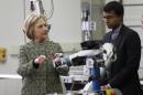 Democratic presidential candidate Hillary Clinton, left, talks with Professor Siddhartha Srinivasa as he describes a robotic arm during a tour of a Robotics Lab at Carnegie Mellon University on a campaign stop, Wednesday, April 6, 2016, in Pittsburgh. (AP Photo/Keith Srakocic)