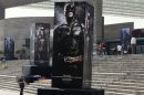 Posters of the film "The Dark Knight Rises" are displayed outside as people wait for the midnight premiere of the final instalment of Nolan's Batman trilogy at the National Auditorium in Mexico City