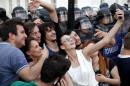 Protestors take a selfie in front of a police cordon during a demonstration in front of the Government building in Skopje Macedonia, on Tuesday, May 5, 2015. Macedonia's opposition leader has accused the country's prime minister of attempting to cover up the 2011 death of a 22-year-old who was beaten by police during post-election celebrations. More than 1,000 people gathered later Tuesday in front of the government building to protest the murder of the young conservative supporter. (AP Photo/Boris Grdanoski)