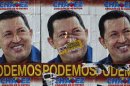 Sticker of opposition candidate Capriles is seen over a poster of Venezuela's President Chavez in downtown Caracas