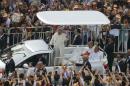 Pope Francis waves to Catholic worshippers as he arrives to lead a mass at Gwanghwamun square in central Seoul