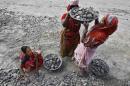 Women labourers work at the construction site of a road in Kolkata