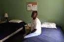 Army veteran Cassandra Lewis, 52, sits on her bed at New Directions women's house