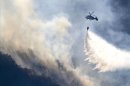 Un helicóptero durante las labores de extinción del incendio que comenzó en la tarde del jueves en Navia de Suarna (Lugo). EFE