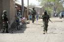 Soldiers walk on April 30, 2013 in the street in the remote northeast town of Baga, Borno State
