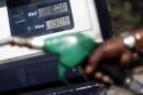 An attendant prepares to refuel a car at a petrol station in downtown Rome
