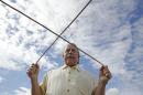 In this photo taken Thursday, Feb. 13, 2014, proprietor Marc Mondavi demonstrates dowsing with "diving rods" to locate water at the Charles Krug winery in St. Helena, Calif. As water supplies shrink during California's historic drought, vineyard owners and other farmers are looking to an ancient, yet scientifically discredited, source for finding water: dowsers. Also known as water witches, dowsers use so-called 