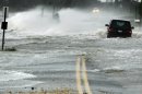 A car drives through water driven onto a roadway by Hurricane Sandy in Southampton, New York