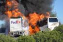 Massive flames are seen devouring both vehicles just after the crash, and clouds of smoke billowed into the sky Thursday April 10, 2014 until firefighters had quenched the fire, leaving behind scorched black hulks of metal. The FedEx tractor-trailer crossed a grassy freeway median in Northern California and slammed into the bus carrying high school students on a visit to a college. At least nine were killed in the fiery crash, authorities said. (AP Photo/Jeremy Lockett)