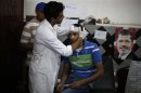 A medic treats a wounded supporter of deposed Egyptian President Mohamed Mursi at a local hospital in Cairo