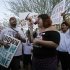 People hold signs as they gather during a protest against Senate Bill 1070 in Phoenix