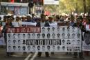 People hold signs bearing images of the 43 missing students, during a demostration demanding information on their whereabouts in Mexico City on November 5, 2014
