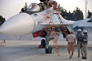 Russian air force crew stand next to a fighter jet …