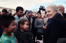 British Actress Vanessa Redgrave (R) talks to refugees and migrants during her visit to the reception facility of Eleonas in Athens on January 5, 2015
