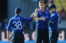 England's Chris Woakes, centre, is congratulated by teammate James Taylor, left, and his captain Eoin Morgan, right, after dismissing New Zealand batsman Martin Guptill during their Cricket World Cup match in Wellington, New Zealand, Friday Feb. 20, 2015. (AP Photo/Ross Setford)