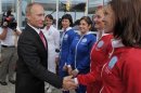 Russian President Vladimir Putin welcomes members of a sky-diving team during an air show dedicated to the 100th anniversary of Russia's Air Force at Zhukovsky outside Moscow