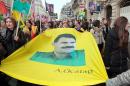 People holding a giant portrait of jailed Kurdistan Workers' Party (PKK) leader Abdullah Ocalan take part in a demonstration on January 11, 2014 in Paris to commemorate the killing of three top Kurdish activists