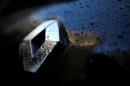 Raindrops cover the logo of French car manufacturer Renault on a automobile seen in Paris